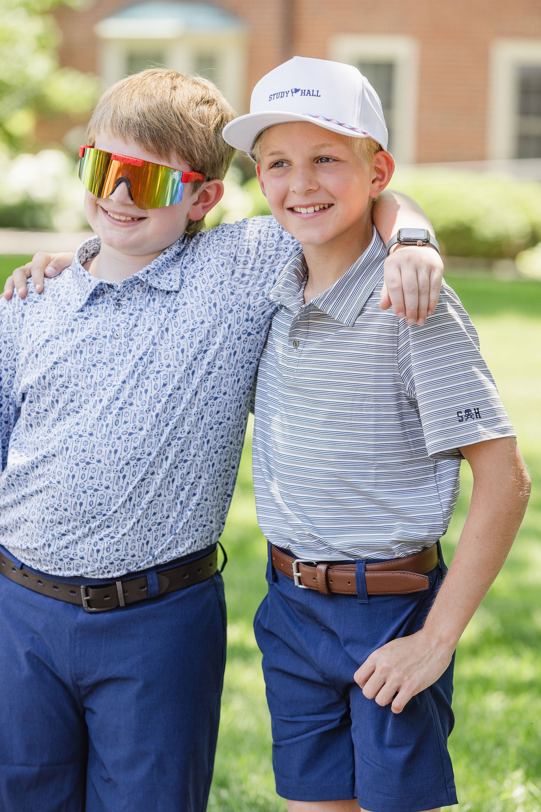 Boys with arm around each other wearing clothing and accessories from Study Hall Kids Clothing outside school