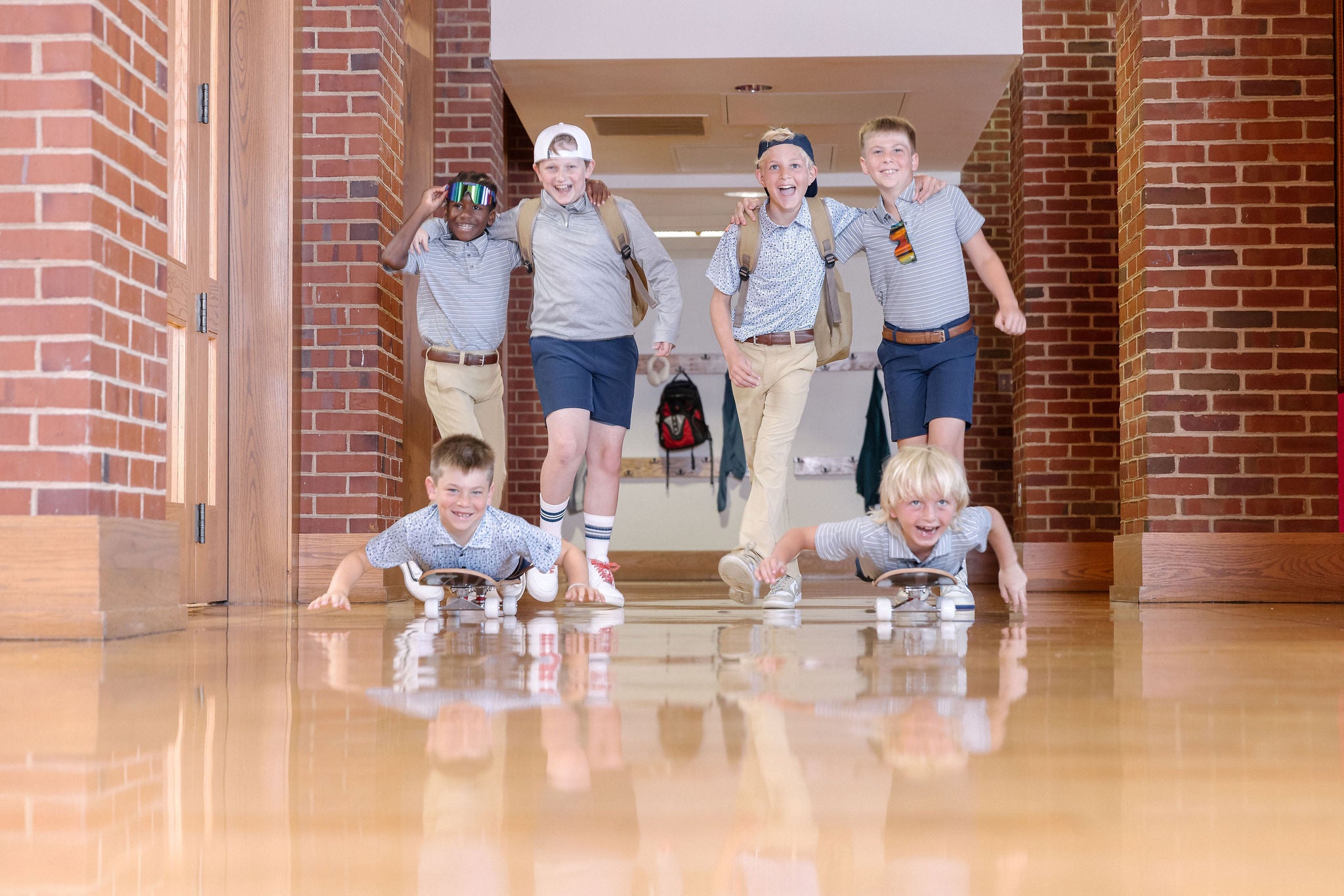 Group of young boys hanging out and playing in school hallway