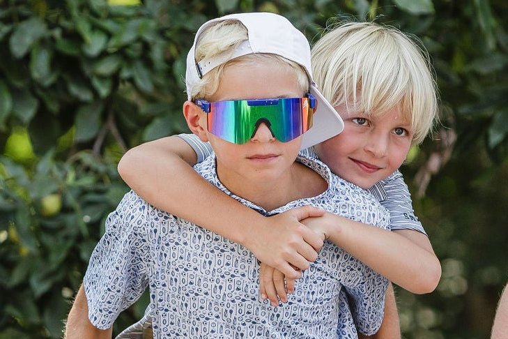 Children giving piggyback ride in front of large tree