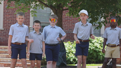 Boys playing with football outside wearing performance wear professional looking clothing for private school